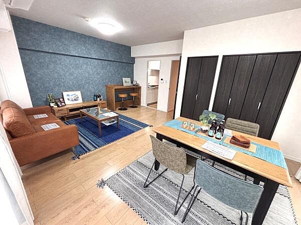 開放感のあるリビングが印象的です。明るい床材とアクセントクロスの組み合わせが空間にメリハリを与えています。ダイニングスペースとリラックススペースがゆったりと配置されています。