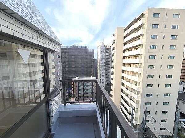 眺望が広がるバルコニーは開放感があります。周囲に高い建物が立ち並び都市的な景色を楽しめます。ガラス戸から室内へもしっかりと光が差し込み明るい印象です。柵のデザインもシンプルで安心感があります。
