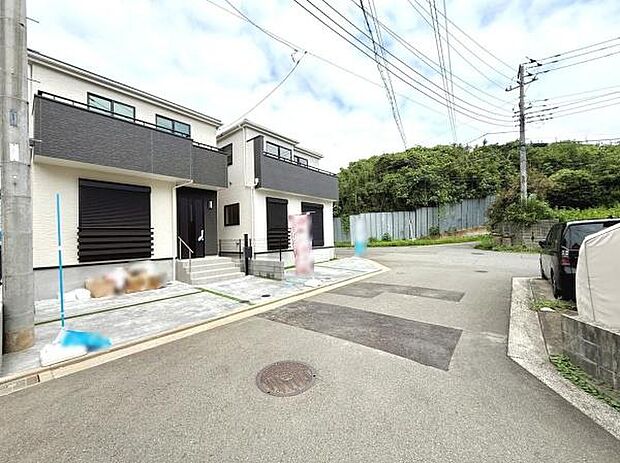 前面道路が広く車の出入りがしやすい現地写真です。周辺は落ち着いた雰囲気で建物の外観も整っています。周囲に高い建物が少なく明るい印象を受けます。現地の状況がよく分かる写真です。