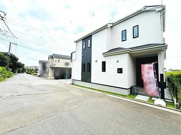 現地写真は明るい雰囲気の住宅を捉えています。前面道路が広く車の出入りがしやすい環境です。周辺には自然も感じられすっきりとした街並みが広がっています。建物の外観も清潔感があります。