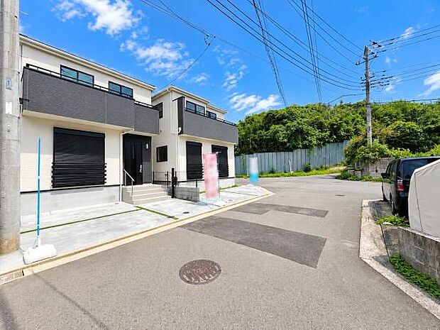 前面道路が広く車の出入りがしやすい現地写真です。周辺は落ち着いた雰囲気で建物の外観も整っています。周囲に高い建物が少なく明るい印象を受けます。現地の状況がよく分かる写真です。