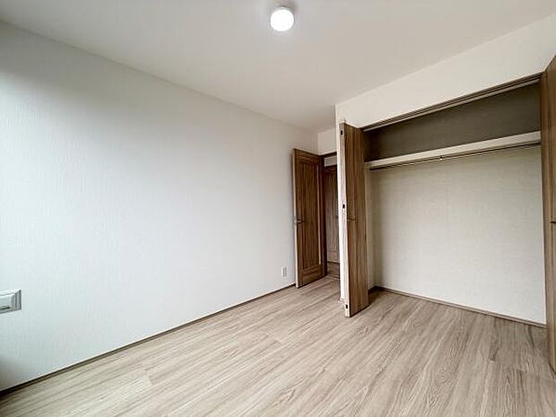 木目調のクローゼットが設けられたお部屋です。扉の内側にはハンガーパイプがあり衣類の整理がしやすい仕様です。