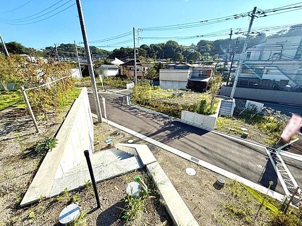 周囲に建物が少なく開放的な現地土地写真です。前面道路が幅広く車の出入りもスムーズに行えます。敷地には高低差がありプラン次第で多様な使い方が期待できます。周辺は落ち着いた雰囲気となっています。