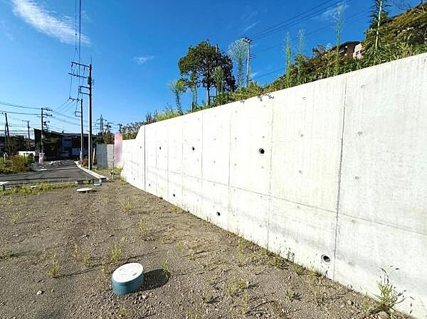 敷地にはコンクリート擁壁があり周囲との境界が明確です。現地土地写真からは日当たりも感じられます。道路やインフラも近くに確認でき周辺環境も分かりやすいです。建築プランにも活用しやすい整形地です。