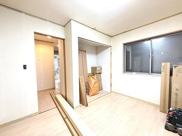 シンプルなデザインが特徴の洋室です。大きな窓からは自然光が入り明るい雰囲気を感じられます。壁にはスペースが確保されており使いやすさも考慮されています。床材の色合いが落ち着いた印象を与えます。