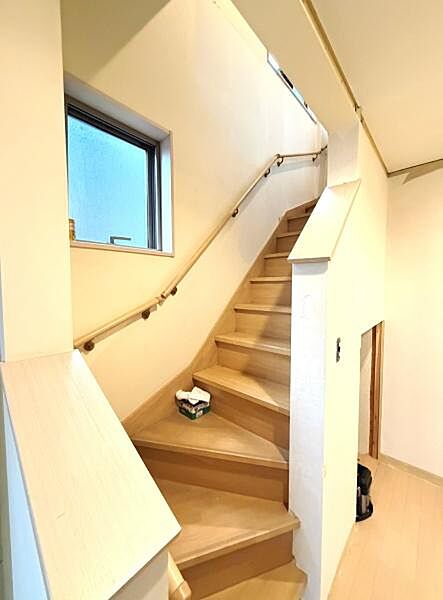 階段部分は明るい色合いの木材が使用されており圧迫感を感じさせない空間となっています。手すりが設置されているため安全面にも配慮されています。階段脇には窓があり外からの自然光が差し込みます。