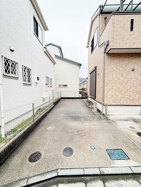 駐車スペースがしっかり確保されています。隣家との距離も適度で車の出し入れがしやすい形状です。コンクリート舗装で日々の手入れも簡単です。フェンスが設置されており安心感が感じられます。