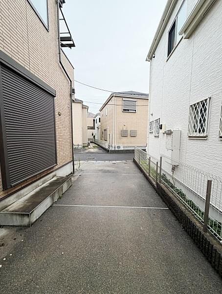 住宅に隣接した駐車場スペースはしっかり舗装されており雨の日も安心です。両側に建物があるため車両を雨や風から守りやすい環境です。入口には段差が少なく出入りがしやすい設計となっています。