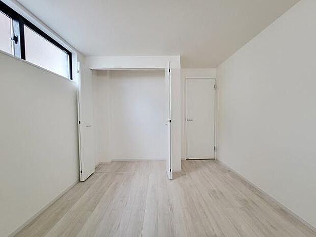 ナチュラルな色合いの床が特徴の洋室です。明るい印象の室内でクローゼットも備えています。高い位置の窓から自然光が入るため開放感があります。シンプルで使いやすい空間です。