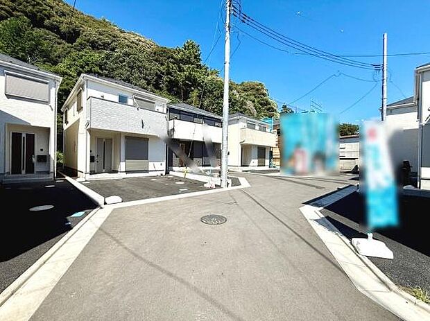 新しい街並みが印象的な前面道路含む現地写真です。各住戸の外観が整っており統一感があります。周囲は自然を感じられる環境で通行しやすい舗装道路が広がっています。日当たりの良い明るい雰囲気が特徴です。