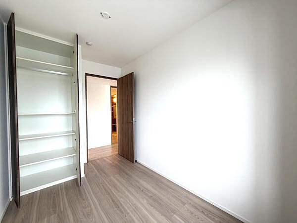 シンプルな収納スペースが備わっています。お部屋全体がホワイトと木目調で統一されています。収納部分は可動棚仕様です。扉付きで見た目もすっきりとしています。整理整頓しやすい設計です。