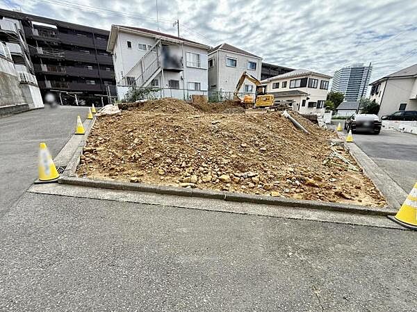 前面道路にしっかりと接道している現地写真です。周辺は住宅が立ち並び落ち着いた雰囲気が感じられます。現場は整地作業が進んでおりすぐに建築を進めることができます。