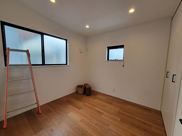 シンプルな内装で落ち着きのある寝室空間です。二面採光により明るさがしっかり確保されています。収納スペースが備わっており整理整頓がしやすいです。照明も複数設置され室内をバランスよく照らしています。