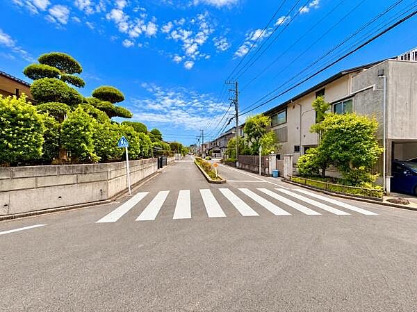 前面道路が広くゆったりとした印象の現地写真です。周辺には緑が多く整えられてい住宅街らしい整然とした雰囲気が感じられます。