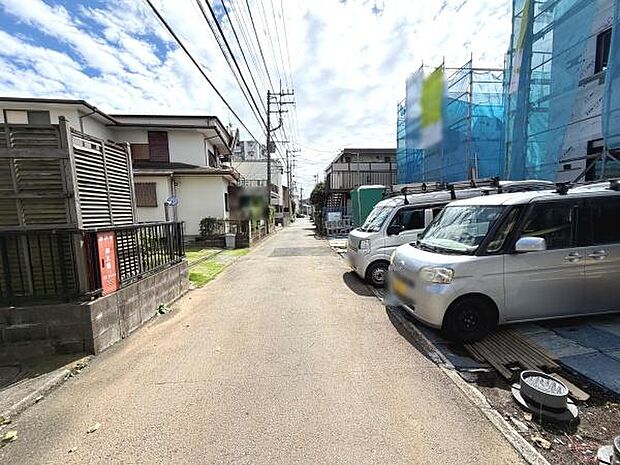 前面道路は幅員があり車の通行もスムーズに行えます。周囲には住宅が立ち並び落ち着いた雰囲気が特徴です。歩道部分も整備されており安心感があります。電柱や配線が整然としていて街並みに調和しています。