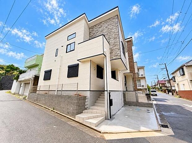 角地に位置する物件で開放感があります。外観はモダンなデザインが特徴です。周辺は落ち着いた住宅街となっています。現地までの道路も幅員があり車の出し入れがしやすいです。