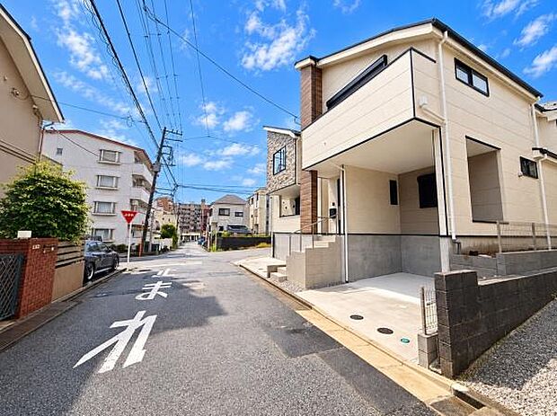 前面道路が広く車の出し入れがしやすそうな現地写真です。周囲には住宅が整然と並んでおり清潔感のある街並みが印象的です。駐車スペースがしっかり確保されています。