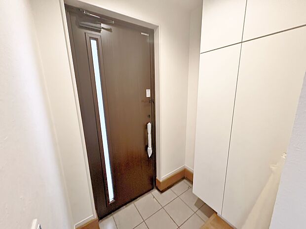 天井近くまで高さがある収納を設けた玄関。