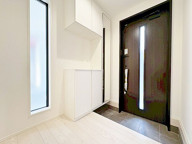 窓から外の光を通す、明るく広い玄関。