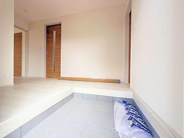 明るくコントラストのある、開放感と清潔感を兼ね備えた玄関。