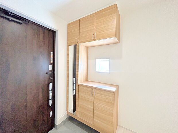 窓から外の光を通す、明るく広い玄関。