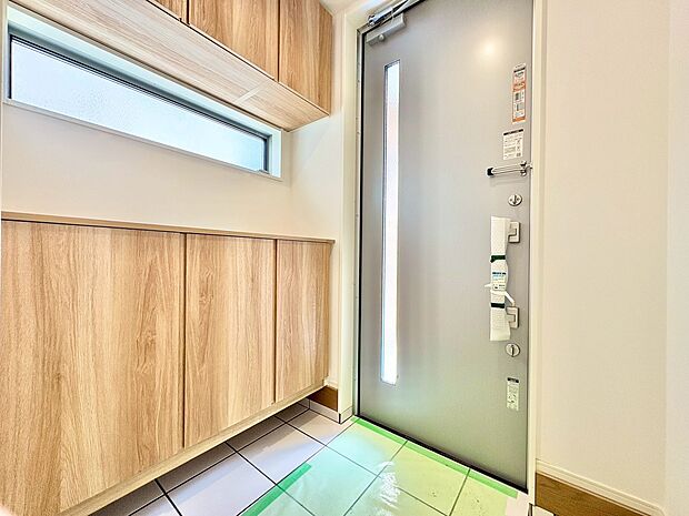 窓から外の光を通す、明るく広い玄関。