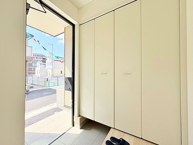 天井近くまで高さがある収納を設けた玄関。