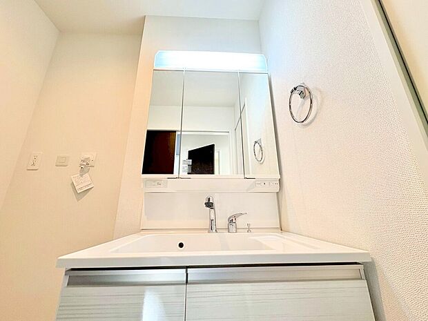 大きくて見やすい三面鏡タイプの清潔感ある洗面台。