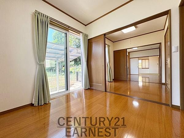 大きな窓から光が差し込み洋室全体が明るく感じられます。壁や床は落ち着いた色合いでさまざまなインテリアに合わせやすい空間です。隣接する部屋と繋げて使える設計で可動式の間仕切りが特徴です。