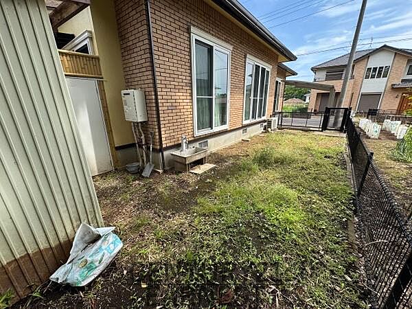 建物横に広がる庭スペースはほどよい広さです。フェンスが設置されており境界線が分かりやすいです。日当たりも入りやすく窓から庭を眺められる配置です。出入り口付近には設備がまとまっています。