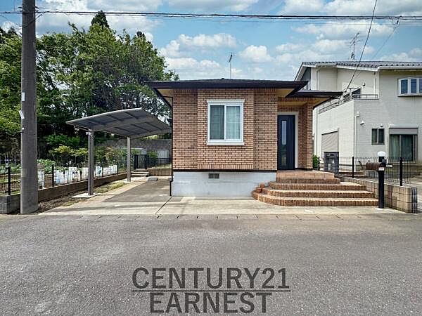 レンガ調の外観が印象的な住宅です。広々とした玄関アプローチがあり段差も低く設計されています。駐車スペースには屋根付きのカーポートが設置されています。静かな住環境が魅力的な立地です。