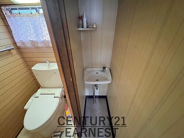 洗面台がすっきりとしたデザインで配置されています。コンパクトな空間を有効活用できます。棚が設けられておりちょっとした小物置きにも便利です。トイレと洗面台の動線も短く効率的です。