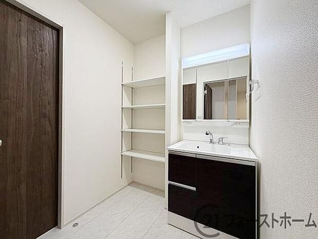 洗面化粧台は人気の三面鏡と便利なシャワー付です。便利な棚もあります。