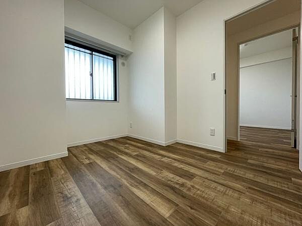 シンプルな内装が特徴の子供部屋です。明るいフローリングで清潔感があります。窓から自然光が入りやすい設計です。隣室へのアクセスもしやすい配置となっています。