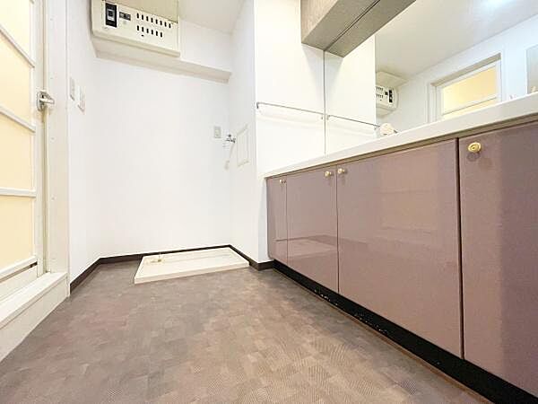 落ち着いたカラーの床と収納が特徴的な洋室です。シンプルな内装で多様なアレンジが楽しめます。天井までの高さが開放感を演出しています。室内は明るく清潔感があります。扉や設備も機能的に配置されています。