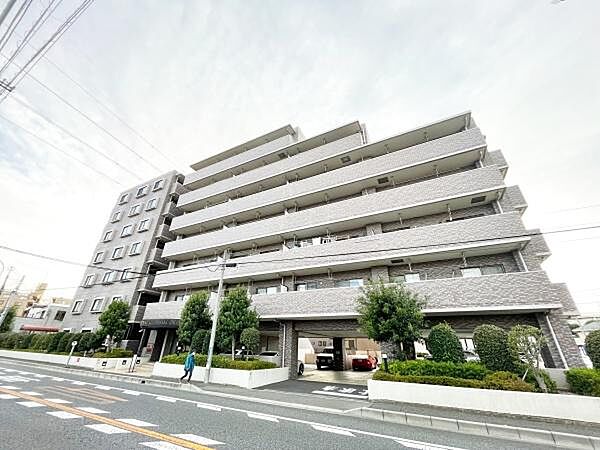 近代的な外観が特徴のマンションです。植栽も整えられており清潔感があります。エントランス周りは広々としていて開放感を感じられます。周囲には歩道もあり安全に配慮された設計です。
