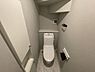 トイレ：落ち着いた色調のトイレです。壁の収納スペースが使いやすい設計になっています。コンパクトながらも機能的な空間が確保されています。棚が設置されており小物の置き場に便利です。