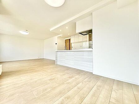 明るい色合いのフローリングが空間全体を広く感じさせます。オープンなレイアウトで開放感があります。キッチンとの一体感があり無駄のないデザインです。収納部分も整理しやすい配置となっています。