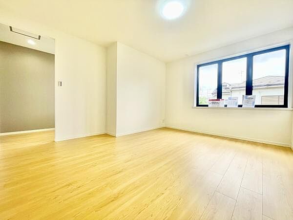 窓からたっぷりと自然光が入る洋室です。明るい床材が空間を広く感じさせます。壁や天井の色合いが落ち着いた雰囲気を演出しています。シンプルな設計で家具の配置もしやすいです。