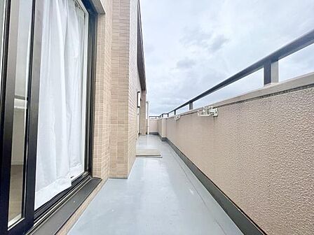 広々としたバルコニーが印象的です。外からの光が差し込み室内を明るく演出します。開放感があり使い勝手の良いスペースです。壁や手すりも清潔感があります。視界が広がる設計になっています。