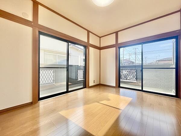 洋室には大きな窓が2面設置されており明るい光が差し込みます。シンプルな内装と木目調のフローリングが室内をすっきりと見せています。バルコニーへのアクセスもスムーズで通風も良好です。