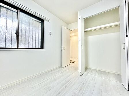 明るい印象の洋室です。クローゼットが備え付けられており収納スペースが確保されています。窓から光が差し込み室内が爽やかに感じられます。床や壁の色合いが統一されており落ち着いた雰囲気です。
