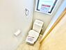 トイレ：窓付きで換気しやすいトイレです。シンプルな内装が空間をすっきりと見せています。壁際に手拭きリングやペーパーホルダーが設置されています。清潔感が漂うトイレ空間です。