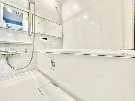 清潔感あふれるバスルームです。広々とした浴槽でリラックスできます。スタイリッシュな壁面が印象的です。鏡やカウンターも使いやすい配置となっています。収納やお手入れのしやすさにも配慮されています。