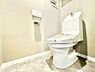 トイレ：明るく清潔感のあるトイレ空間です。壁リモコン式で操作も快適です。フロアもお手入れしやすい設計です。使い勝手の良いレイアウトが特徴です。トイレットペーパーホルダーや棚も設置されています。
