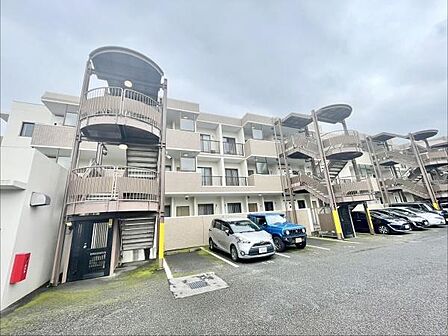 シンプルで機能的なデザインの外観が特徴の物件です。整然とした駐車スペースがあり毎日の出入りが便利です。外階段も設置されており移動のしやすさを感じます。建物全体が落ち着いた色合いで統一されています。
