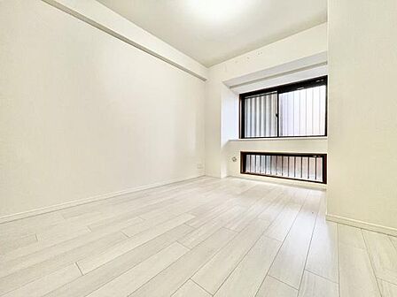 明るい色合いの床と壁が洋室全体をすっきりとした印象にしています。窓が二箇所あり光を多く取り入れることができます。ゆったりとした空間でシンプルなデザインが特徴です。家具の配置もしやすそうな洋室です。