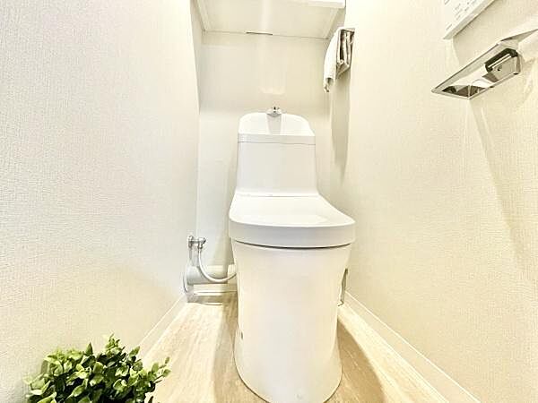 明るく清潔感のあるトイレ空間です。コンパクトながらもゆとりを感じられるレイアウトが魅力です。ナチュラルな床色とシンプルなデザインがすっきりとした印象を与えます。小物を置いても映えるスペースです。