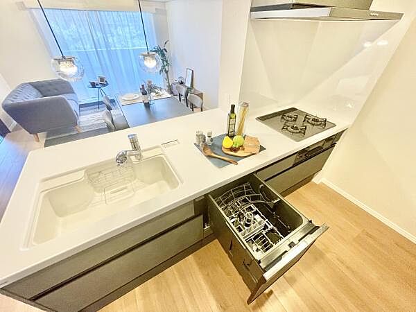 開放感のある対面式キッチンでリビングとの一体感を感じられます。食器洗い乾燥機や三口コンロが備わっており日々の家事もスムーズに進みます。広々とした作業スペースも確保されていて効率的に調理を行えます。