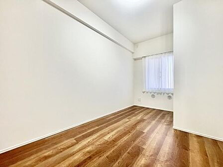 ナチュラルなフローリングが印象的な子供部屋です。白を基調とした内装で清潔感があります。窓から自然光が入り空間が明るく見えます。シンプルな設計で家具の配置も考えやすいお部屋です。
